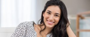 Brunette woman smiling showing off white teeth thanks to cosmetic dentistry